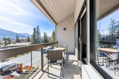 a balcony with a table and chairs and a view at Best Western Plus Banff International Lodge in Banff