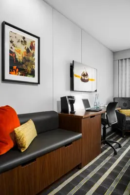 an office with a couch and a desk with a laptop at Hotel Arts in Calgary
