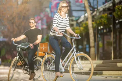 a man and a woman riding bikes down a street at Hotel Arts in Calgary