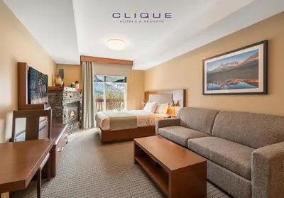 a hotel room with a bed and a couch at Falcon Crest Lodge by CLIQUE in Canmore