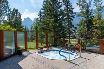 two children playing in a swimming pool on a patio at Falcon Crest Lodge by CLIQUE in Canmore