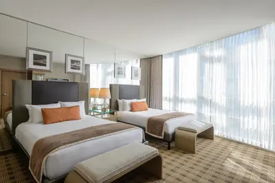 a hotel room with two beds and a large window at Loden Vancouver in Vancouver