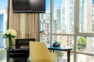 a room with a desk and a large window at Loden Vancouver in Vancouver