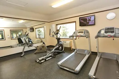 a gym with several exercise bikes and treadmills at Holiday Inn Express Hotel & Suites Vernon by IHG in Vernon
