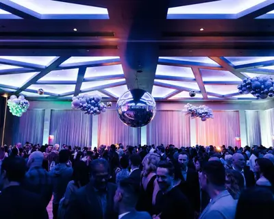 a large crowd of people in a room with balloons at Paradox Vancouver in Vancouver