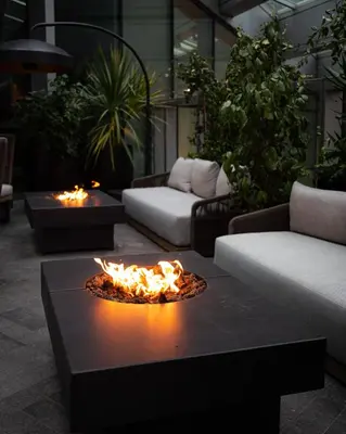 a living room with a fire pit in the middle at Paradox Vancouver in Vancouver