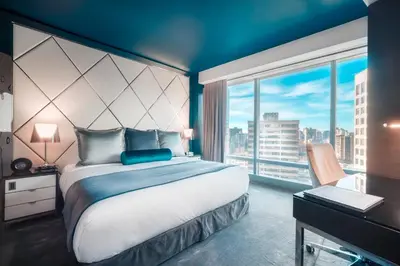 a bedroom with a large bed and a large window at Paradox Vancouver in Vancouver