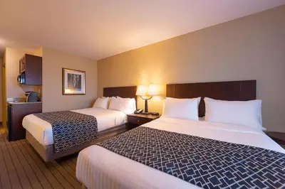 a hotel room with two beds and two lamps at Bayview Hotel in Courtenay