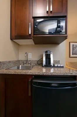 a kitchen with a sink and a microwave at Bayview Hotel in Courtenay
