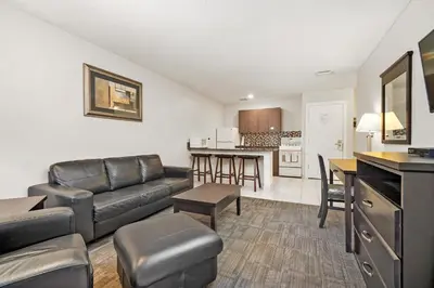 a living room with a couch and a kitchen at Guest House Inn & Suites in Edson