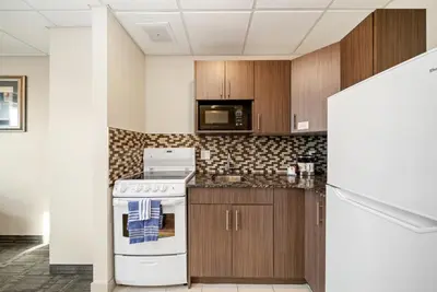 a kitchen with a stove and a microwave at Guest House Inn & Suites in Edson