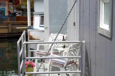 a couple of chairs sitting on a porch at A Float Home B&B in Fisherman’s Wharf in Victoria