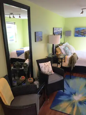 a bedroom with a mirror and a bed and a chair at A Float Home B&B in Fisherman’s Wharf in Victoria