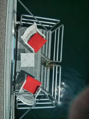 a balcony with two chairs in the water at A Float Home B&B in Fisherman’s Wharf in Victoria