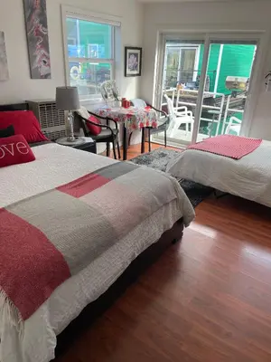 a bedroom with two beds and a dining room with a table at A Float Home B&B in Fisherman’s Wharf in Victoria