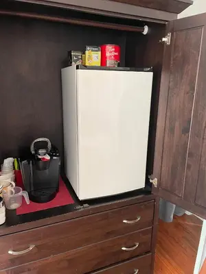 a white refrigerator sitting on top of a cabinet at A Float Home B&B in Fisherman’s Wharf in Victoria