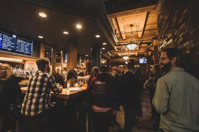 a group of people standing around a bar in a restaurant at Swans Brewery, Pub & Hotel in Victoria