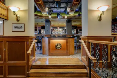 a bar in a restaurant with stairs leading to a bar at Strathcona Hotel in Victoria