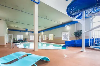 a large indoor swimming pool with a blue slide at Holiday Inn Express Hotel & Suites Edson by IHG in Edson