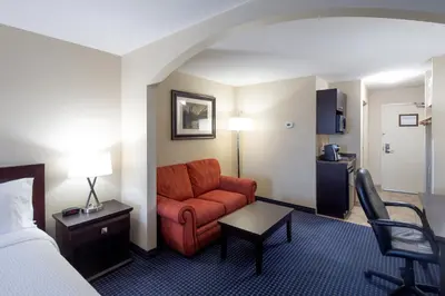 a hotel room with a couch and a bed at Holiday Inn Express Hotel & Suites Edson by IHG in Edson