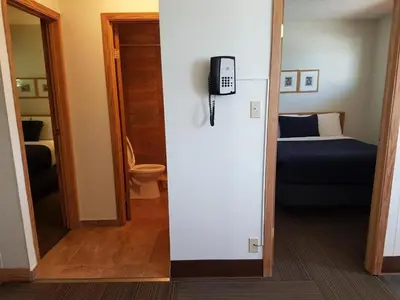 a room with a bedroom with a bed and a phone at Pines Motel in Hinton