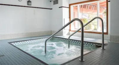 a jacuzzi tub in a bathroom with a window at Cahilty Lodge in Sun Peaks
