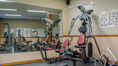 a gym with several exercise bikes in front of a mirror at Cahilty Lodge in Sun Peaks