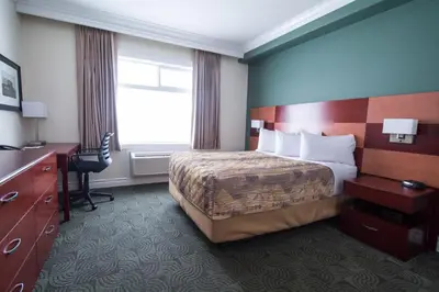 a hotel room with a bed and a desk and a window at Nova Inn Manning in Manning