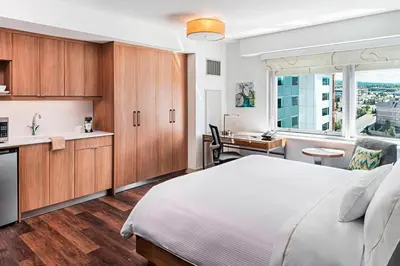 a bedroom with a bed and a kitchen with a window at Element Calgary Airport in Calgary