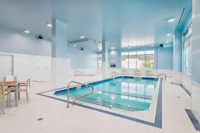 a large indoor pool with a table and chairs and a table and a tablerisome at Element Calgary Airport in Calgary