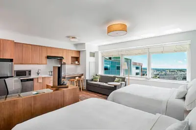 a bedroom with two beds and a kitchen with a view at Element Calgary Airport in Calgary