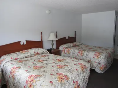 a hotel room with two beds and a lamp at Bonanza Gold Motel & RV Park in Dawson City