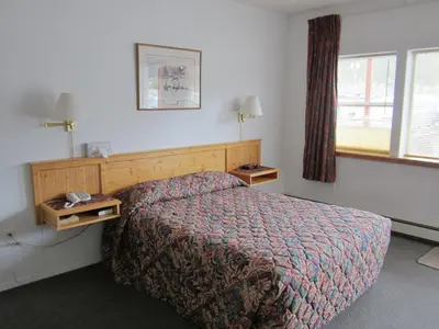 a hotel room with a bed and a window at Bonanza Gold Motel & RV Park in Dawson City