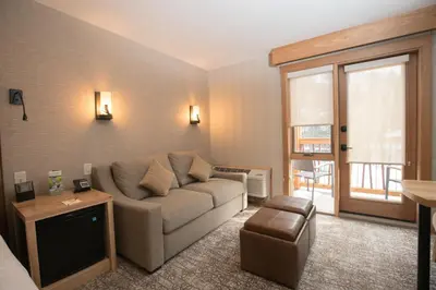 a living room with a couch and a television at Moose Hotel and Suites in Banff