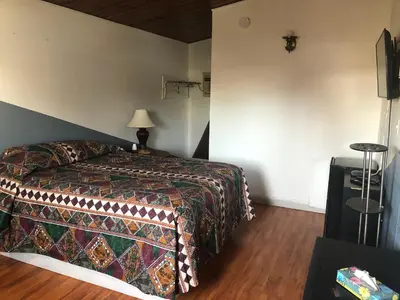 a bedroom with a bed with a colorful blanket at Superlodge Lloydminster in Lloydminster