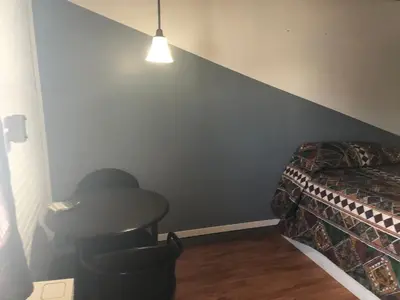 a bedroom with a table and a bed and a lamp at Superlodge Lloydminster in Lloydminster