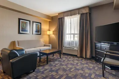 a hotel room with a couch and a television at Best Western PLUS Fox Creek in Fox Creek