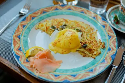 a plate of food with an omelet on a table at Beaujolais Boutique B&B at Thea's House- Adults Only in Banff