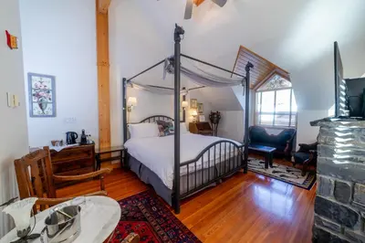 a bedroom with a canopy bed and a desk at Beaujolais Boutique B&B at Thea's House- Adults Only in Banff