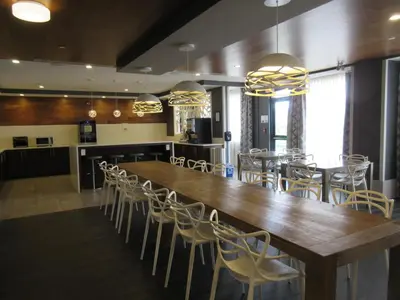 a large dining room with a large wooden table and chairs at Best Western Plus Airdrie Gateway in Airdrie