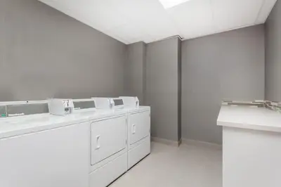 a white bathroom with white cabinets and sinks at Best Western Plus Airdrie Gateway in Airdrie