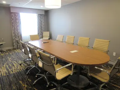 a conference room with a large wooden table and chairs at Best Western Plus Airdrie Gateway in Airdrie