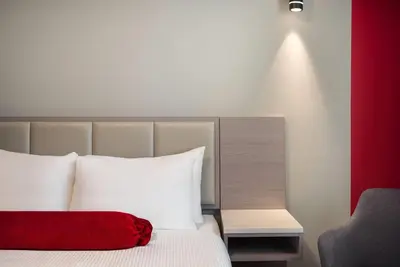 a hotel room with a bed and a chair at Ramada by Wyndham West Edmonton Hotel & Suites in Edmonton