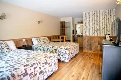 a hotel room with two beds and a desk at Jasper Gates Resort in Jasper
