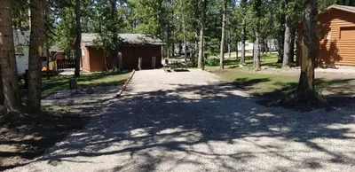a dirt road in front of a cabin with trees at Jasper Gates Resort in Jasper