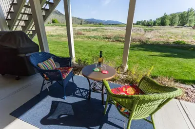 a table and chairs on a porch with a bottle of wine at Overlander B&B in Kamloops