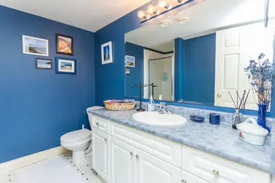 a blue bathroom with a sink and a toilet at Overlander B&B in Kamloops