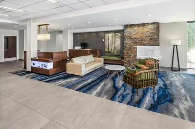 a lobby with furniture and a stone wall at Fairfield Inn & Suites by Marriott Edmonton North in Edmonton