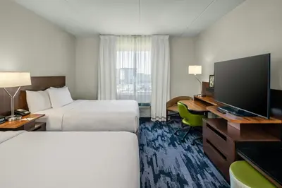 a hotel room with two beds and a flat screen tv at Fairfield Inn & Suites by Marriott Edmonton North in Edmonton