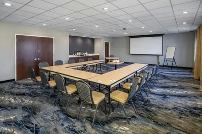 a conference room with a table and chairs and a whiteboard at Fairfield Inn & Suites by Marriott Edmonton North in Edmonton